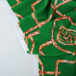 Load image into Gallery viewer, Orange Bamboo Lattice on Kelly Green Nylon Spandex Tricot | Designer Deadstock
