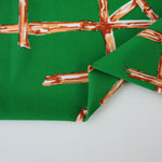Load image into Gallery viewer, Orange Bamboo Lattice on Kelly Green Nylon Spandex Tricot | Designer Deadstock

