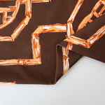 Load image into Gallery viewer, Rust Bamboo Lattice on Chocolate Nylon Spandex Tricot | Designer Deadstock
